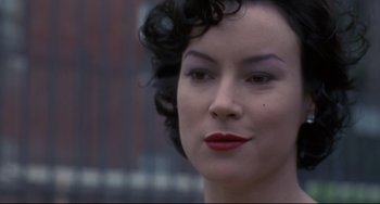 Movie still from “Bound” (1996), directed by Lilly Wachowski – A person wearing a black and red dress; Close Up shot, Over the shoulder angle