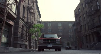 Movie still from “Bound” (1996), directed by Lilly Wachowski – A red and white truck parked on a city street; Extreme Wide shot, Low angle