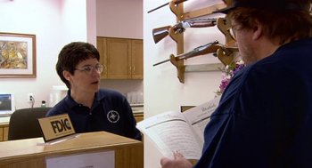 Movie still from “Bowling for Columbine” (2002), directed by Michael Moore – A woman is talking to another woman in a store; Medium shot, Over the shoulder angle