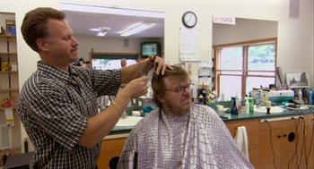 Movie still from “Bowling for Columbine” (2002), directed by Michael Moore – A man getting his hair cut at a barber shop; Medium shot, Over the shoulder angle