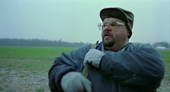 Movie still from “Bowling for Columbine” (2002), directed by Michael Moore – A man in a baseball cap holding a baseball bat; Close Up shot, Low angle