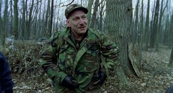 Movie still from “Bowling for Columbine” (2002), directed by Michael Moore – A man in a camouflage jacket standing next to a tree; Medium shot, Low angle
