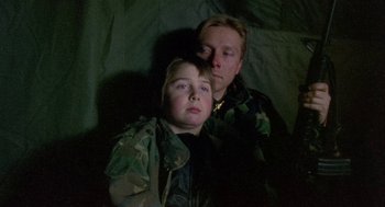 Movie still from “Bowling for Columbine” (2002), directed by Michael Moore – A man and a boy in military fatigues; Close Up shot, Low angle