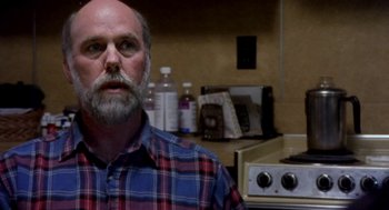 Movie still from “Bowling for Columbine” (2002), directed by Michael Moore – A man with a beard and a plaid shirt in a kitchen; Close Up shot, Low angle