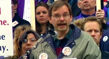 Movie still from “Bowling for Columbine” (2002), directed by Michael Moore – A man is giving a speech at a political rally; Close Up shot, High angle