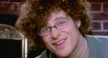 Movie still from “Bowling for Columbine” (2002), directed by Michael Moore – A person wearing a wig and eyeglasses; Extreme Close Up shot, High angle