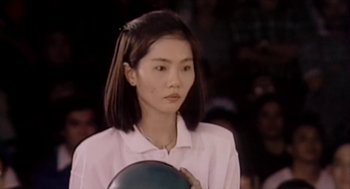 Movie still from “Bowling for Columbine” (2002), directed by Michael Moore – A young woman holding a ball in her hands; Close Up shot, High angle