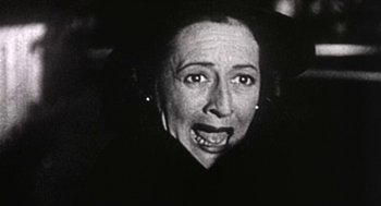 Movie still from “Bowling for Columbine” (2002), directed by Michael Moore – An old photo of a woman with a surprised look on her face; Close Up shot, Low angle