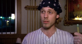 Movie still from “Bowling for Columbine” (2002), directed by Michael Moore – A man wearing a baseball uniform and a hat; Close Up shot, High angle