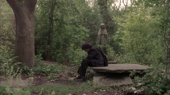 Movie still from “Boy A” (2007), directed by John Crowley – A person sitting on a bench in the woods; Wide shot, Low angle