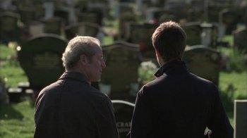 Movie still from “Boy A” (2007), directed by John Crowley – Two men are standing in front of a grave; Close Up shot, Over the shoulder angle