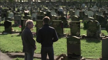 Movie still from “Boy A” (2007), directed by John Crowley – Two men are standing in front of a grave; Wide shot, Over the shoulder angle