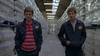 Movie still from “Boy A” (2007), directed by John Crowley – Two young men standing next to each other in a warehouse; Medium shot, Low angle
