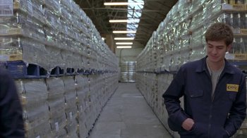 Movie still from “Boy A” (2007), directed by John Crowley – A man standing in front of stacks of papers in a warehouse; Medium shot, Low angle