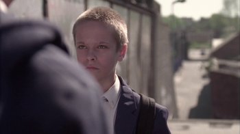 Movie still from “Boy A” (2007), directed by John Crowley – A boy in a suit and a backpack; Close Up shot, Over the shoulder angle