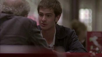 Movie still from “Boy A” (2007), directed by John Crowley – A man sitting at a table with another man in front of him; Close Up shot, Over the shoulder angle