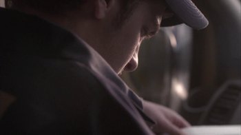 Movie still from “Boy A” (2007), directed by John Crowley – A man in a hat looking down; Extreme Close Up shot, Low angle