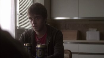Movie still from “Boy A” (2007), directed by John Crowley – A man sitting at a table with two cans of beer; Medium shot, Over the shoulder angle