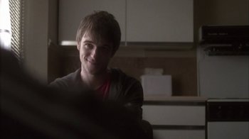 Movie still from “Boy A” (2007), directed by John Crowley – A young man smiling for the camera in a kitchen; Close Up shot, Over the shoulder angle