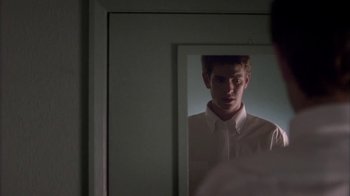 Movie still from “Boy A” (2007), directed by John Crowley – A reflection of a young man in a mirror; Close Up shot, Over the shoulder angle