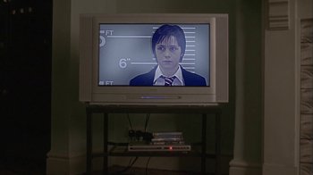 Movie still from “Boy A” (2007), directed by John Crowley – A television set with a picture of a man on the screen; Medium shot, Low angle
