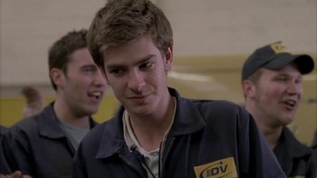 Movie still from “Boy A” (2007), directed by John Crowley – A young man in an idv jacket is smiling for the camera; Close Up shot, Over the shoulder angle
