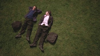 Movie still from “Boy A” (2007), directed by John Crowley – Two men laying in the grass next to each other; Wide shot, Overhead angle