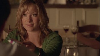 Movie still from “Boy A” (2007), directed by John Crowley – A woman sitting at a table with a glass of red wine; Close Up shot, Over the shoulder angle