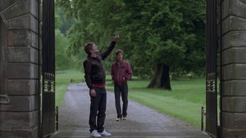 Movie still from “Boy A” (2007), directed by John Crowley – Two men standing on the side of a road; Wide shot, Low angle