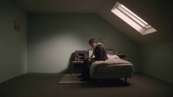 Movie still from “Boy A” (2007), directed by John Crowley – A man sitting on top of a bed with a laptop; Wide shot, Low angle