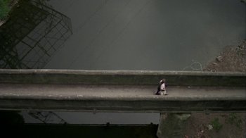 Movie still from “Boy A” (2007), directed by John Crowley – A bird sitting on the side of a bridge; Extreme Wide shot, Overhead angle