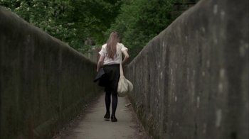 Movie still from “Boy A” (2007), directed by John Crowley – A woman walking down a bridge with a bag; Wide shot, High angle