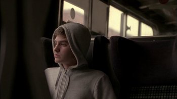 Movie still from “Boy A” (2007), directed by John Crowley – A man sitting in a seat on a bus; Medium shot, Low angle