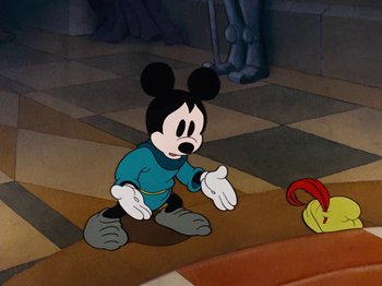 Movie still from “Brave Little Tailor” (1938), directed by Burt Gillett – A cartoon of mickey mouse sitting on the ground; Wide shot, High angle