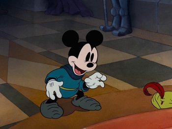 Movie still from “Brave Little Tailor” (1938), directed by Burt Gillett – A cartoon of a mickey mouse in a blue shirt; Medium shot, Over the shoulder angle