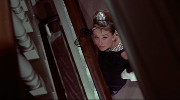 Movie still from “Breakfast at Tiffany's” (1961), directed by Blake Edwards – A person wearing a dress and a tiara; Medium shot, Overhead angle