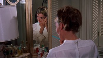 Movie still from “Breakfast at Tiffany's” (1961), directed by Blake Edwards – A woman looking in the mirror while brushing her teeth; Close Up shot, Over the shoulder angle
