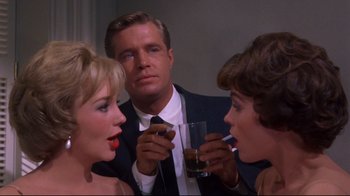 Movie still from “Breakfast at Tiffany's” (1961), directed by Blake Edwards – A man and two women are drinking at a party; Close Up shot, Over the shoulder angle