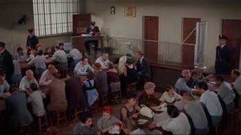 Movie still from “Breakfast at Tiffany's” (1961), directed by Blake Edwards – A group of people sitting at tables in a room; Wide shot, High angle
