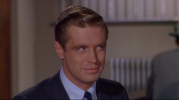 Movie still from “Breakfast at Tiffany's” (1961), directed by Blake Edwards – A person wearing a suit and tie; Close Up shot, Over the shoulder angle