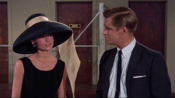 Movie still from “Breakfast at Tiffany's” (1961), directed by Blake Edwards – A man and a woman standing next to each other; Close Up shot, Over the shoulder angle