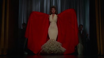 Movie still from “Breakfast at Tiffany's” (1961), directed by Blake Edwards – A woman in a white dress and a red cape; Wide shot, Low angle