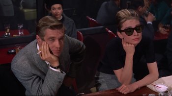 Movie still from “Breakfast at Tiffany's” (1961), directed by Blake Edwards – A man and a woman sitting at a table in front of each other; Medium shot, Over the shoulder angle