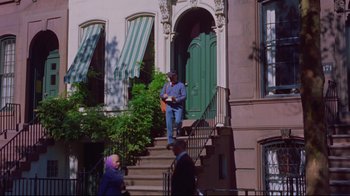 Movie still from “Breakfast at Tiffany's” (1961), directed by Blake Edwards – A man sitting on the steps of a house; Wide shot, Low angle