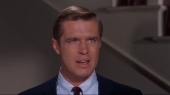 Movie still from “Breakfast at Tiffany's” (1961), directed by Blake Edwards – A person wearing a suit and tie; Close Up shot, Over the shoulder angle