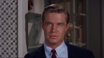 Movie still from “Breakfast at Tiffany's” (1961), directed by Blake Edwards – A person wearing a suit and tie; Close Up shot, Over the shoulder angle