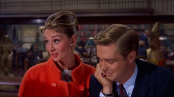 Movie still from “Breakfast at Tiffany's” (1961), directed by Blake Edwards – A man and a woman are sitting next to each other; Medium shot, Over the shoulder angle