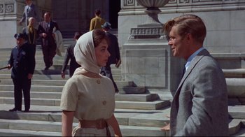 Movie still from “Breakfast at Tiffany's” (1961), directed by Blake Edwards – A man and a woman standing next to each other on steps; Medium shot, Over the shoulder angle