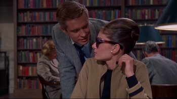 Movie still from “Breakfast at Tiffany's” (1961), directed by Blake Edwards – A man and a woman are looking at each other in a library; Medium shot, Over the shoulder angle