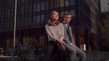 Movie still from “Breakfast at Tiffany's” (1961), directed by Blake Edwards – A man and a woman sitting next to each other in front of a building; Medium shot, Low angle